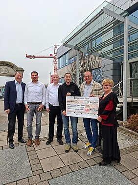 Spendenübergabe symbolischer Scheck